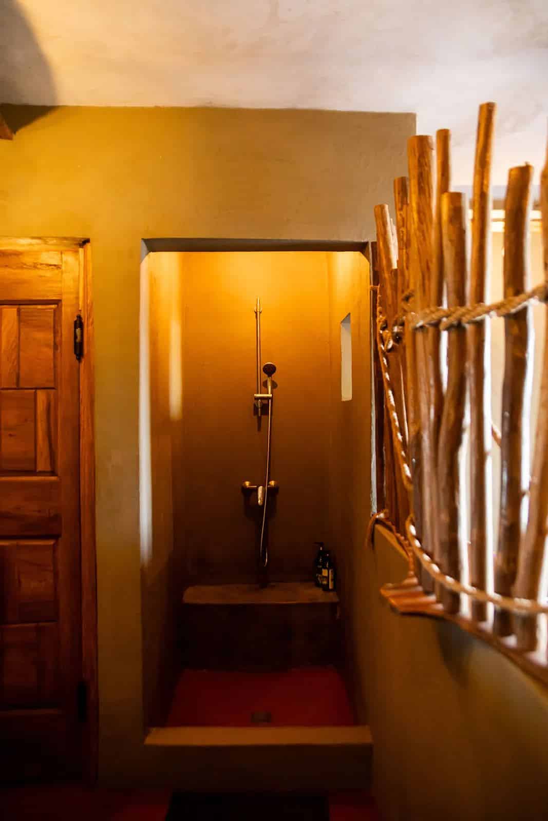 Espace douche aux tons ocre et séparation en bois naturel