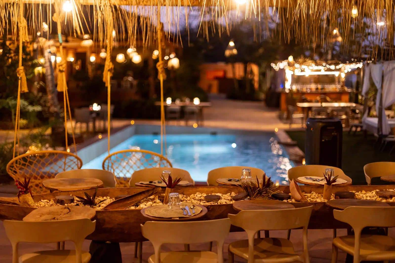 Table dressée pour le dîner devant la piscine éclairée